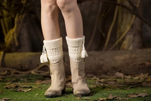 Detail of cream cable knit leg warmers with side tassels paired with vintage boots