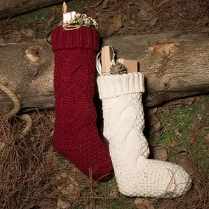 Knitted Christmas stockings with twist patterns in burgundy and cream for holiday decor