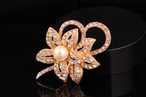 Macro shot of twin flower brooch with sparkling rhinestones and a central white pearl