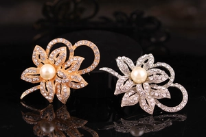 Detailed macro view of elegant floral brooches with rhinestones and large white pearls
