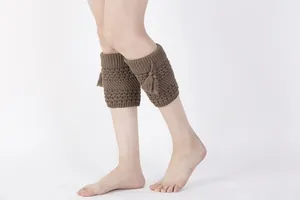 Detail of coffee brown cable knit leg warmers with fringes and scalloped ribbed edges
