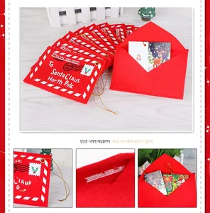 Close-up of red felt Christmas envelopes with Santa Claus embroidery and golden hanging cords