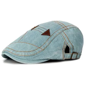 Washed light blue denim flat cap with vintage stitching and adjustable leather buckle
