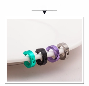 Macro detail of four-color C-shaped clip-on earrings displayed on white ceramic