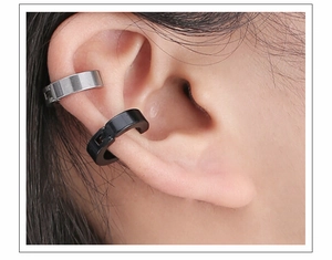 Close-up of black and silver titanium steel clip-on earrings worn on the ear bone