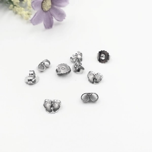 Macro shot of 316L stainless steel butterfly earring backs on a white surface