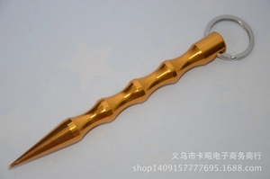 Macro detail of gold metal tactical kubotan keychain with non-slip grip for self-defense