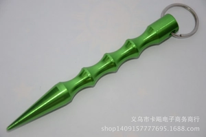 Macro detail of a green aluminum kubotan featuring ergonomic finger grooves and a sharp tip