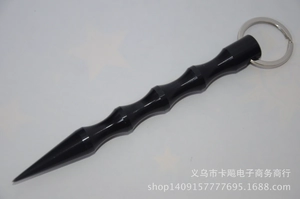 Close-up of black aluminum kubotan keychain with anti-slip grooves and a pointed tip