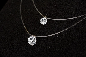 Close-up of two transparent fishing line necklaces with sparkling cubic zirconia pendants