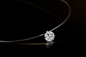 Macro detail of clear fishing line necklace with a sparkling round zircon stone