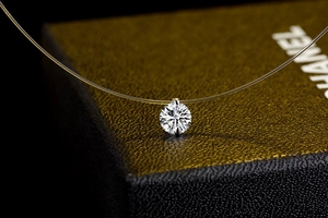 Macro shot of a brilliant cut zircon pendant on a clear invisible fishing line necklace