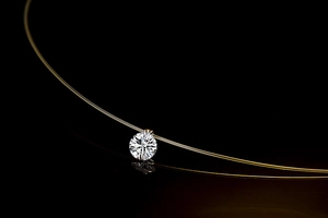 Macro shot of single round-cut zircon pendant with clear invisible fishing line chain