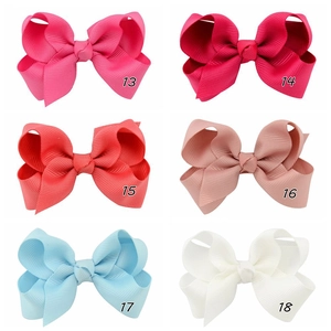 Detail view of grosgrain ribbon hair bows in six colors including pink and light blue