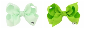 Detail view of light green and grass green grosgrain ribbon bow clips numbered 19 and 20