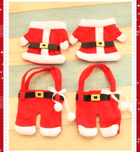 Detail view of four pieces Christmas mini clothes and trousers cutlery holders on wood