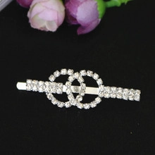 Detailed view of silver rhinestone hair clip featuring an interlocking CC design on black background