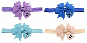 Detail of four colorful ribbon fishtail bows for children in purple and blue tones