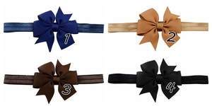 Detail of four ribbon fishtail bow headbands in navy, tan, dark brown, and black