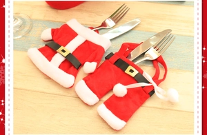 Detailed view of Christmas red clothes and pants cutlery holders on a wooden table
