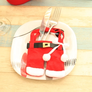 Christmas Santa pants cutlery holder on white floral plate and wooden table
