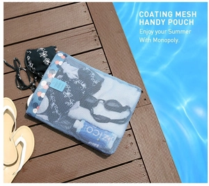 Blue mesh storage pouch with floral trim holding sunscreen and sunglasses by the pool