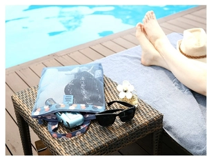 Blue mesh beach bag featuring floral patterns with vintage camera inside by the pool