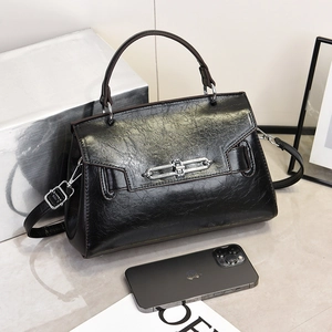 Classic black crossbody bag with oily leather texture and silver chain buckle detail