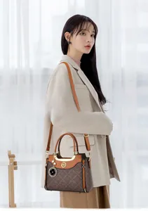 Detailed view of the vintage brown monogram handbag featuring gold hardware and clover charm