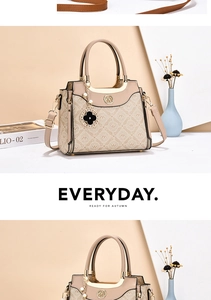 Detail of beige PU leather handbag showing letter patterns and clover pearl ornament