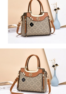 Close-up of monogram canvas bag with leather trim and decorative clover metal charm