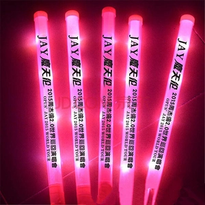 Detailed view of red LED glow sticks with custom tour text glowing in the dark