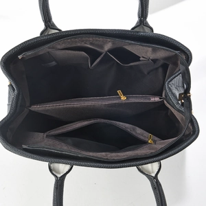 Interior view of black pebbled leather tote showing multi-layer compartments and gold zipper
