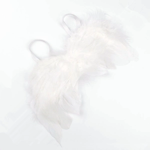 Close-up of soft white feather wings with delicate elastic straps for kids photo props