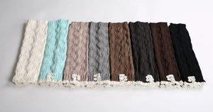 Detail view of knitted leg warmers featuring lace trim and vintage buttons in various colors