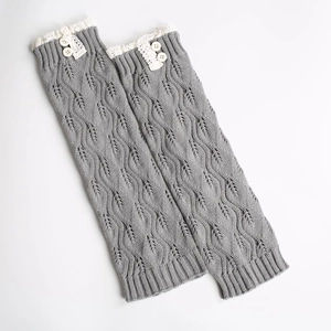 Gray knitted leg warmers with delicate white lace trim and wooden button accents
