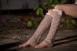 Detail of coffee knit leg warmers with delicate white lace trim and button accents