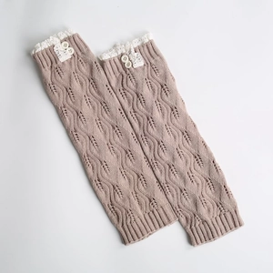 Detail of khaki knitted leg warmer featuring lace trim and two small white buttons