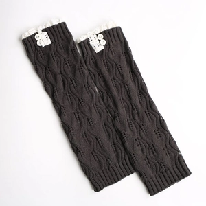 Detail of dark grey knit leg warmers with white lace trim and buttons on the top