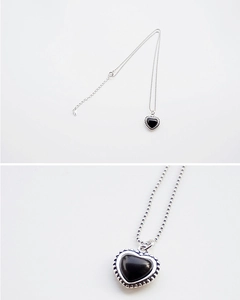 Detail of a vintage S925 silver heart pendant with black onyx and elegant ball chain