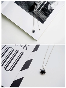 Macro detail of S925 silver heart necklace featuring black inlay and beaded edge design