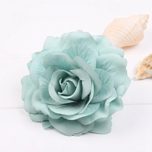 Close-up of mint blue silk rose hair clip with realistic layered petals and seashell decor