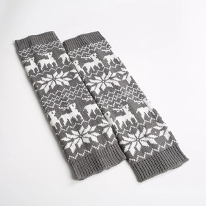 Close-up of gray knitted leg warmers featuring white elk and snowflake patterns