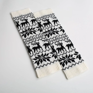 Close-up of knitted leg warmers featuring reindeer and snowflake Christmas patterns