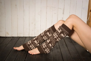 Close-up of knit leg warmers featuring snowflake and alpaca patterns in brown and beige