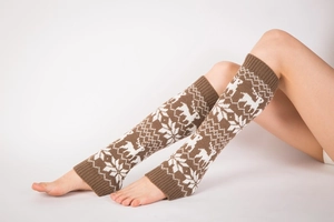 Detail of knitted leg warmers with reindeer and snowflake patterns for winter warmth