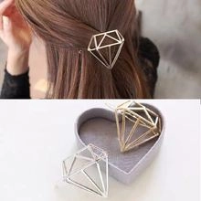 Macro shot of minimalist geometric hollow diamond-shaped hairpins in gold and silver