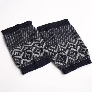 Detail of navy and cream geometric knit leg warmers with ribbed cuffs on white background