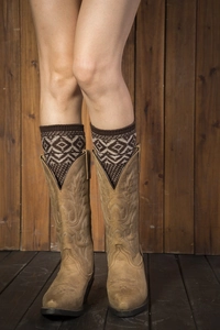 Close-up of bohemian geometric knit leg warmers worn with brown leather western boots