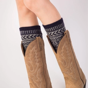 Jambières bohèmes en tricot à motifs géométriques portées sur bottes en cuir marron